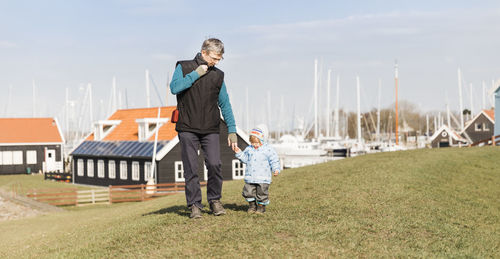 Grandfather and grandson walking on field