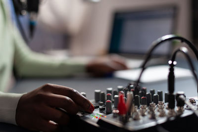 Cropped hand of woman using sound mixer