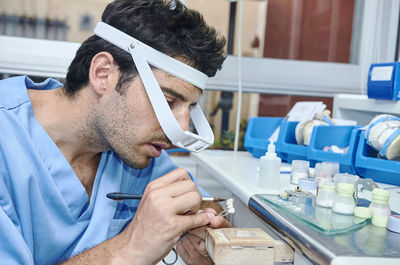 Close-up of dental worker cleaning dentures