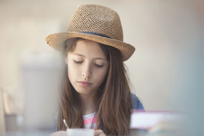 Teenage girl wearing hat at sidewalk cafe