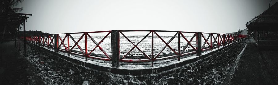 Bridge over river against sky in city