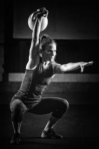 Young woman lifting exercise equipment at gym