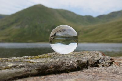 Reflection of crystal ball on water in lake