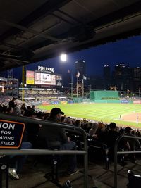 People sitting in stadium at night