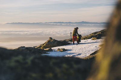 Full length of woman on snowcapped mountain against sky during sunset