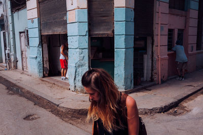 Full length of woman on street against buildings in city