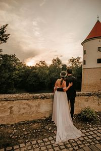 Newlywed couple looking toward sunset, marriage, bride and groom.