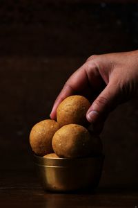 Close-up of hand holding ice cream on table