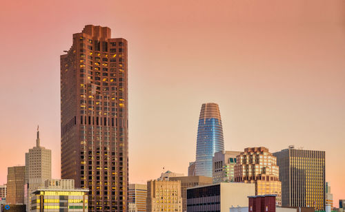 Skyscrapers against clear sky during sunset