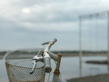 Close-up of wicker basket on lake against sky