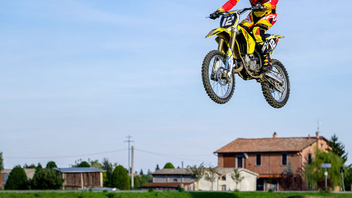 Low section of man performing motorcycle stunt in mid-air