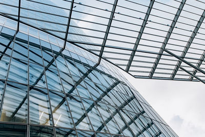 Low angle view of glass building against sky