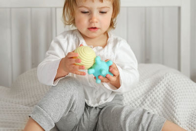 Baby girl playing tactile knobby balls. young child hand plays sensory massage ball