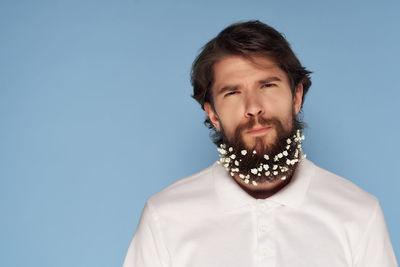 Portrait of young man against blue background