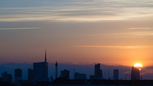 Silhouette buildings against sky during sunset