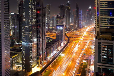 High angle view of illuminated city street and buildings at night