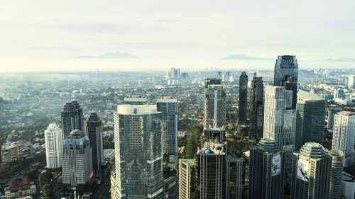 High angle view of modern buildings against cloudy sky