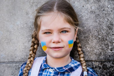 Close-up of cute girl against wall