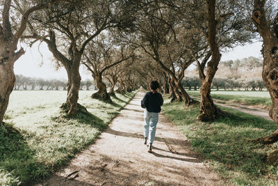 Rear view of man walking on field