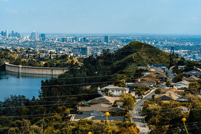 High angle view of buildings by river against sky