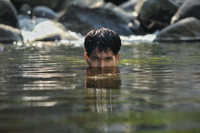 Portrait of teenage boy swimming in lake