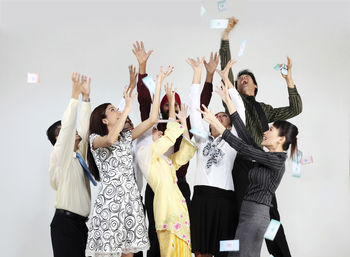 Cheerful business colleagues looking up against white background