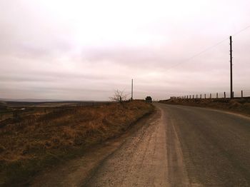 Empty road against cloudy sky