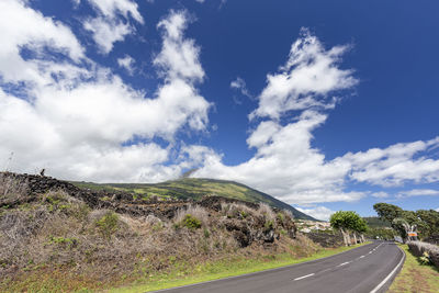 Empty road along landscape against sky