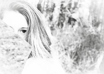 Close-up portrait of young woman against tree