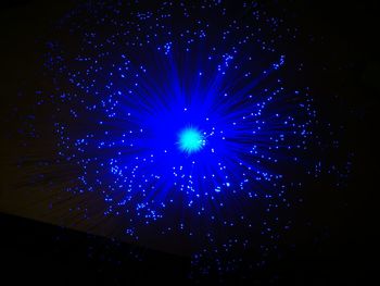 Low angle view of fireworks against blue sky