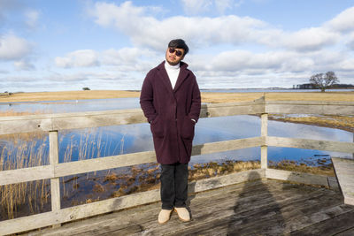 Portrait of young man standing against sky