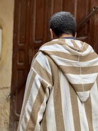 Rear view of a man standing by an ancient door in fez