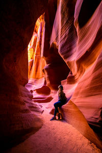 Full length of woman leaning on rock formation at grand canyon