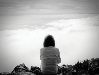 Woman standing on mountain against sky