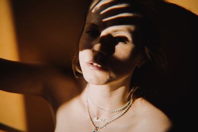 Close-up portrait of a young woman with drop shadows of her hand