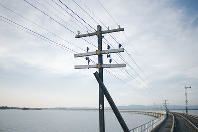 Low angle view of telephone pole against sky