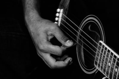 Cropped hand of man playing guitar