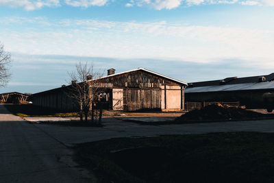 Abandoned building by road against sky