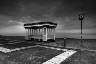 Gazebo at beach against cloudy sky