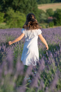 Rear view of woman walking on field