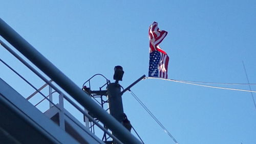 Low angle view of flag against clear blue sky