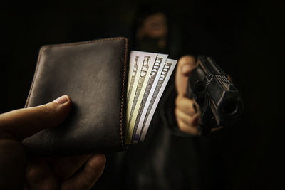 Midsection of man holding book against black background