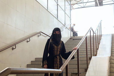 Muslim woman in national clothes in city in an underground passage.