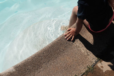 High angle view of girl sitting by swimming pool