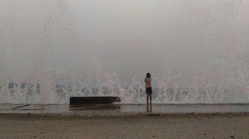Man standing by sea against sky