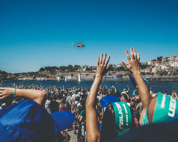 People enjoying over sea against clear blue sky