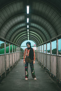 Full length portrait of girl standing on footbridge