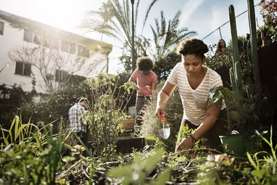 Woman working with friends in community garden