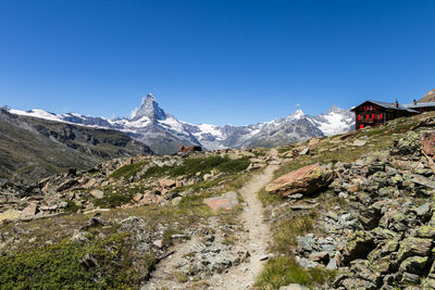 Scenic view of snowcapped mountains against clear blue sky