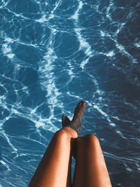 Low section of woman legs in swimming pool